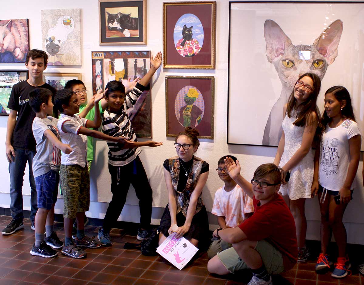 Young artists enthusiastically present their artwork to the photographer